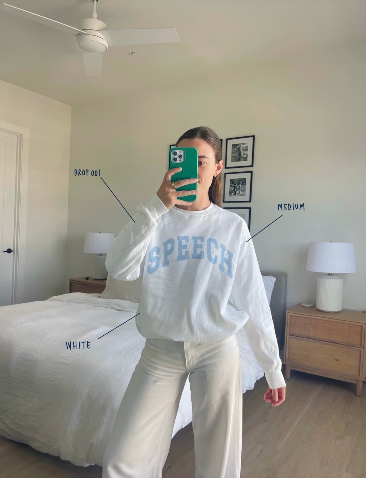 Raney wearing the white SPEECH crewneck in a size medium